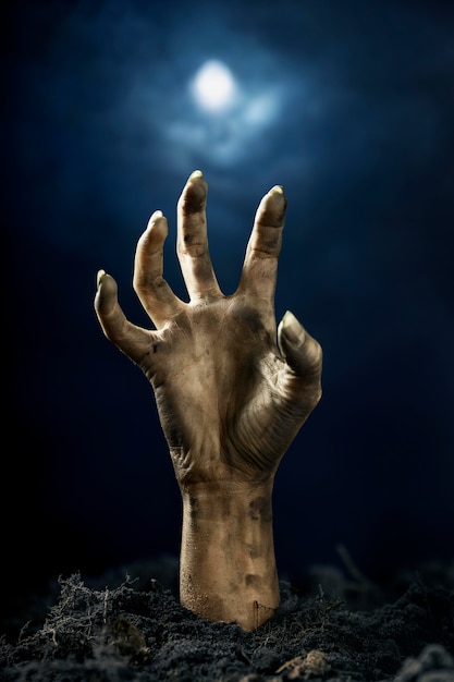 Scary zombie hand from the ground at night