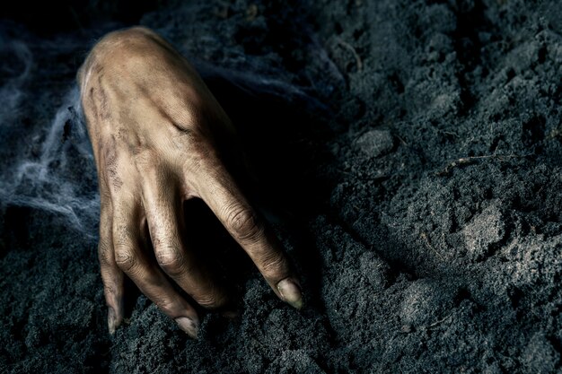 Scary zombie hand from the ground at night