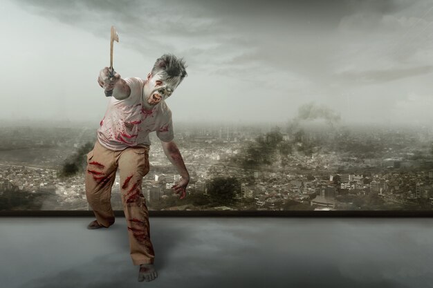 Scary zombie with blood and wound on his body holding sickle walking with the ruined city background