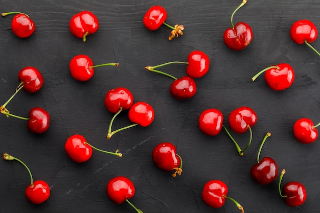 Scattered cherries on a dark grey table. flat lay.