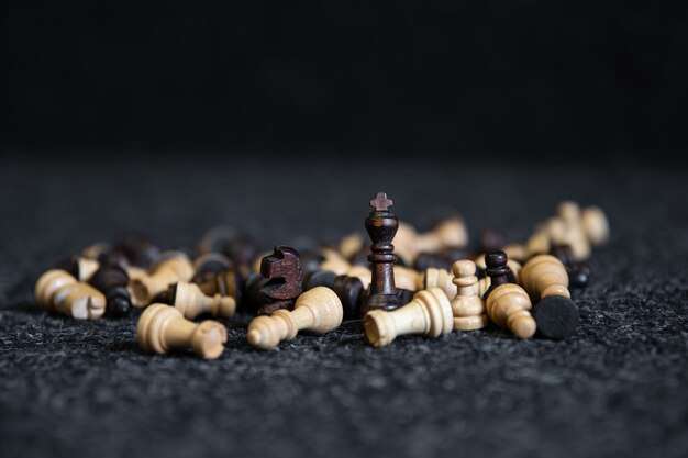 Scattered chess pieces on a blurred black background