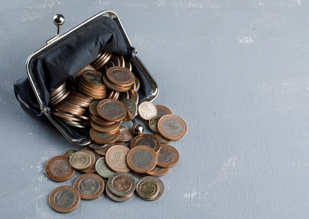  scattered coins from purse on plaster table .