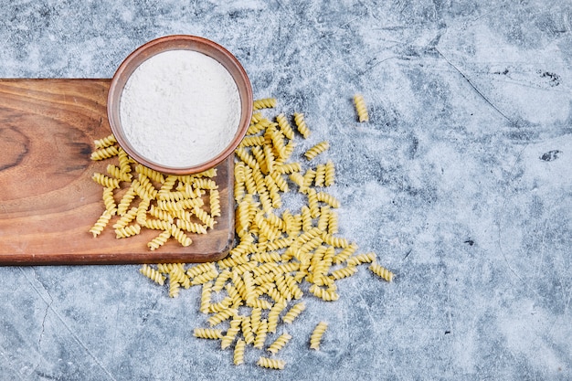 Pasta sparsa e ciotola di farina.