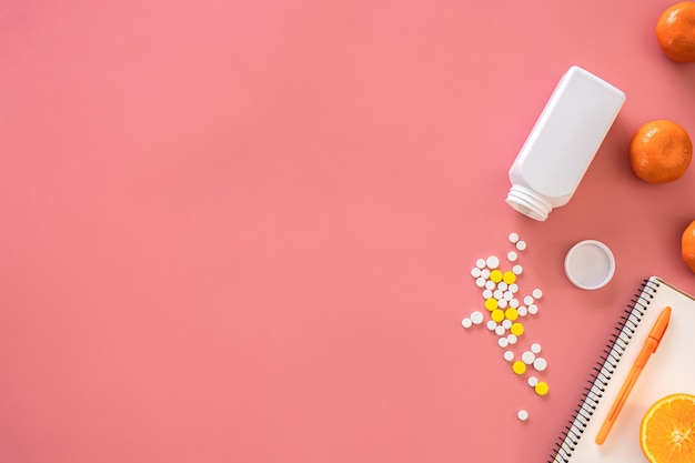 Scattered pills on a pink background flat lay