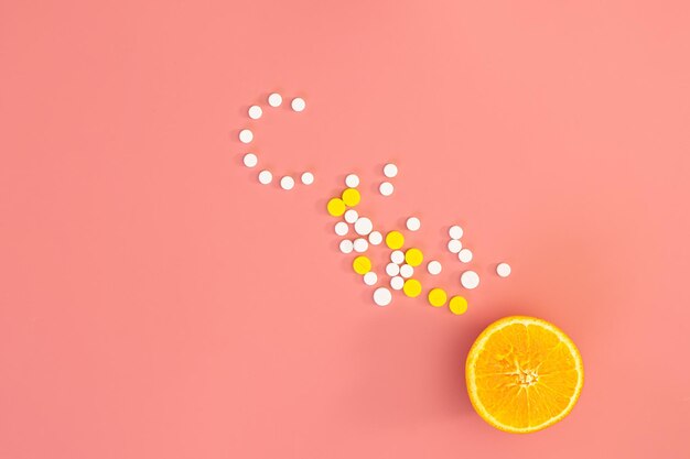 Scattered pills on a pink background flat lay