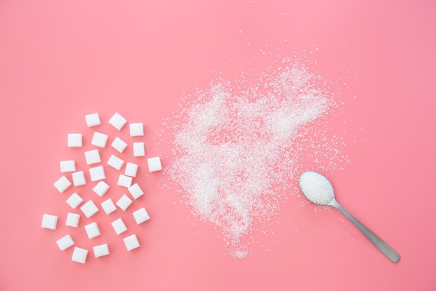 Free photo scattered sugar and sugar cubes on a pink background flat lay