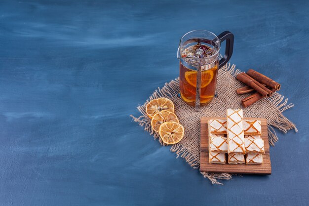 Scattered waffle cookies with a cup of herbal tea . 