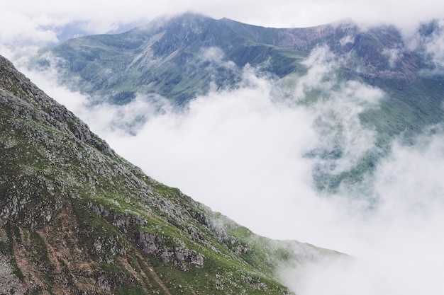 Scenery of smoke coming out of the mountains in the middle of a green view