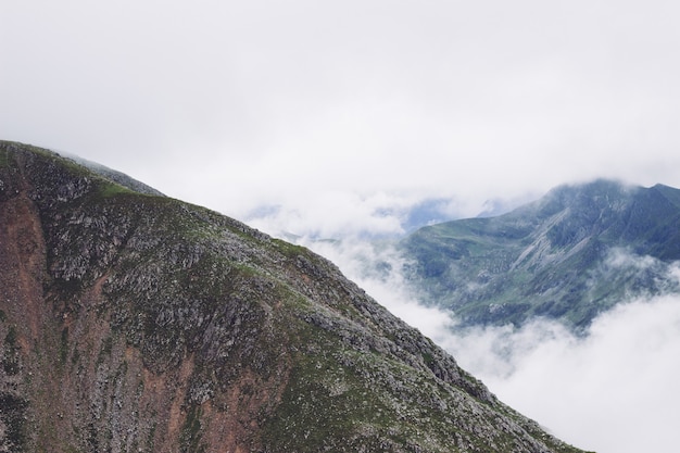 Scenery of smoke coming out of the mountains in the middle of a green view