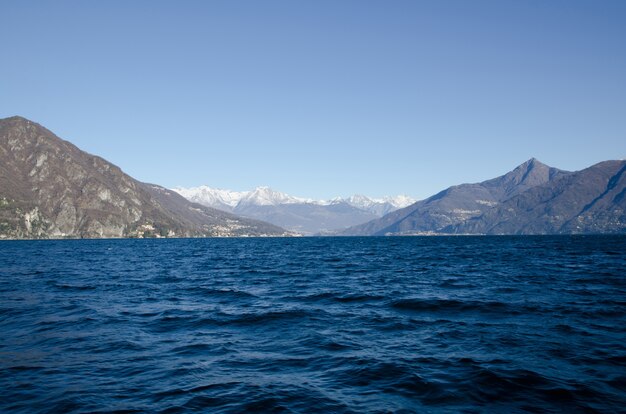 Scenic lake with mountains in the horizon against a blue sky