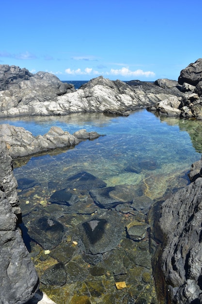 Живописный спокойный природный бассейн среди скал на побережье Арубы