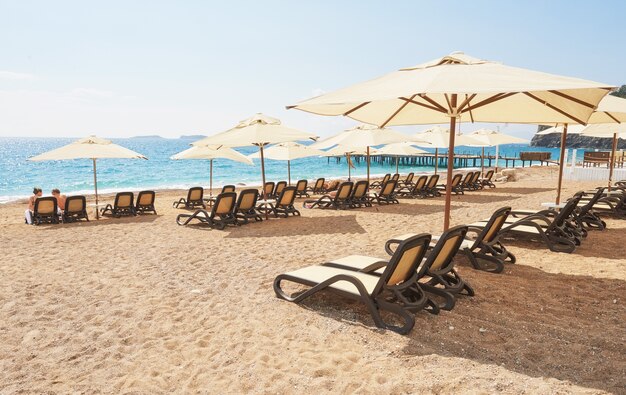 Scenic view of private sandy beach with sun beds from the sea and the mountains. Amara Dols Vita Luxury Hotel. Resort. Tekirova Kemer. Turkey.