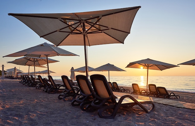 Scenic view of sandy beach on the beach with sun beds and umbrellas open against the sea and mountains. Hotel. Resort. Tekirova-Kemer. Turkey