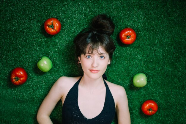 Sceptic woman near apples and tomatoes