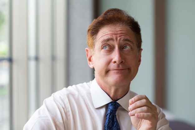 Free photo sceptical businessman looking up