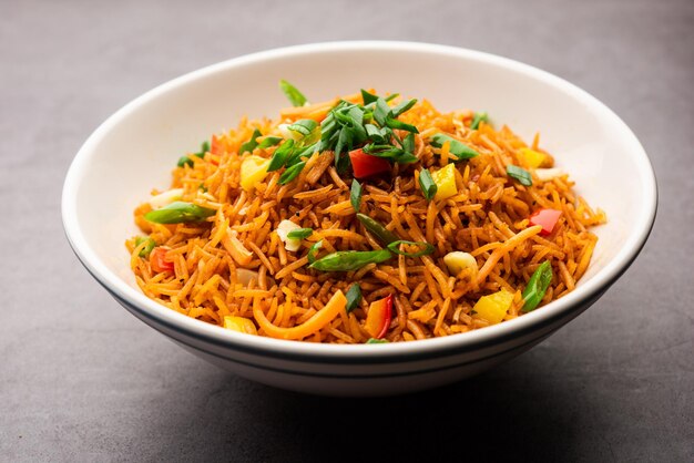 シェズワンチャーハンマサラまたは四川料理は、箸を添えた皿またはボウルで提供される人気のインド中華料理です。セレクティブフォーカス