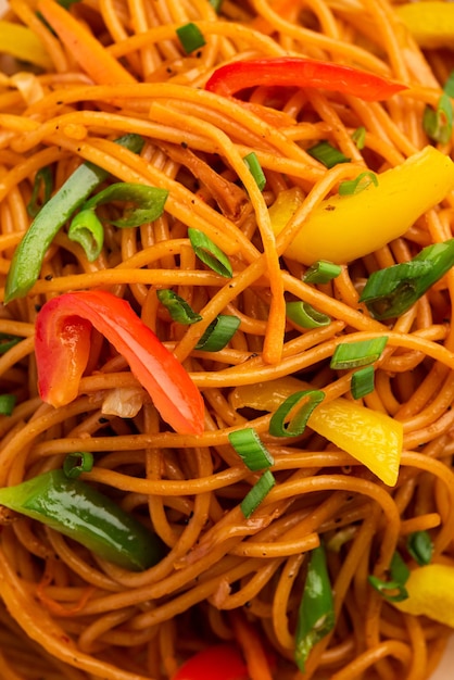Schezwan noodles or szechwan vegetable hakka noodles or chow mein is a popular indo-chinese recipes, served in a bowl or plate with wooden chopsticks Premium Photo
