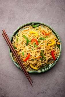 Schezwan noodles o verdure szechwan hakka noodles o chow mein è una popolare ricetta indo-cinese, servita in una ciotola o in un piatto con bacchette di legno
