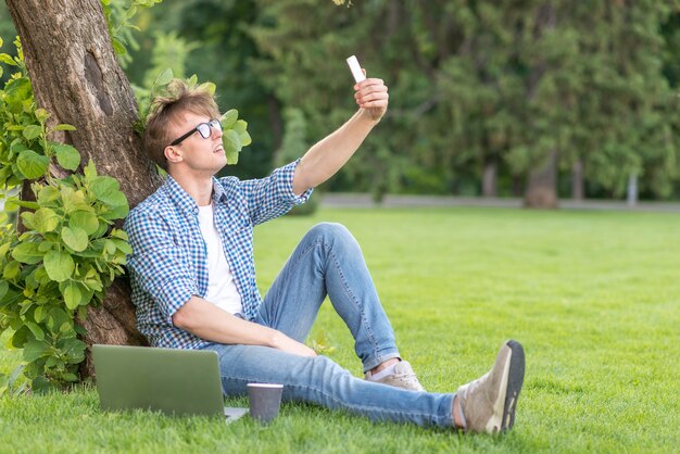 School boy taking selfie in park