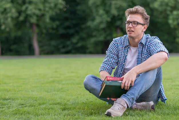 School boy with book in park