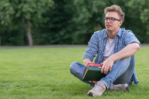 Школьник с книгой в парке