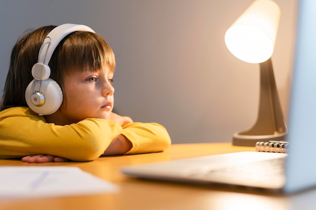 School boy in yellow shirt taking virtual classes