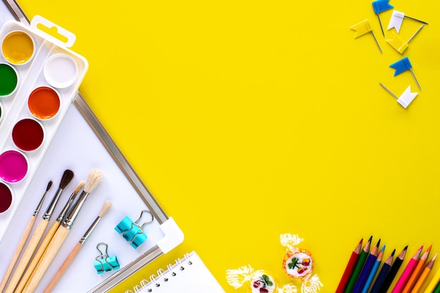 School colorful stationery on yellow background with copyspace.