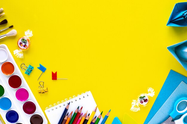 School colorful stationery on yellow background with copyspace.