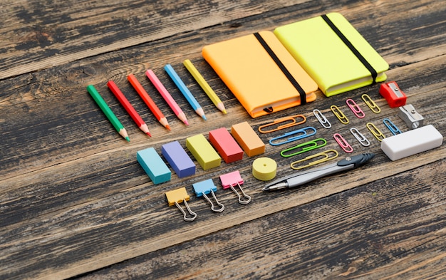 School  concept with copybooks, school supplies on wooden table high angle view.