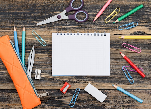 School  concept with notebook, school supplies on wooden table flat lay.