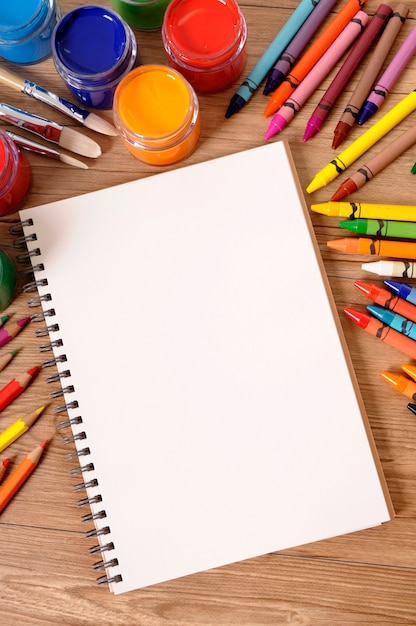 School desk with notepad and colored crayons