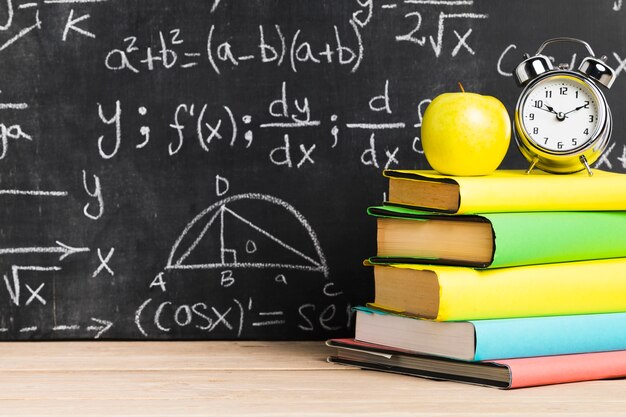 School desk with textbooks near blackboard