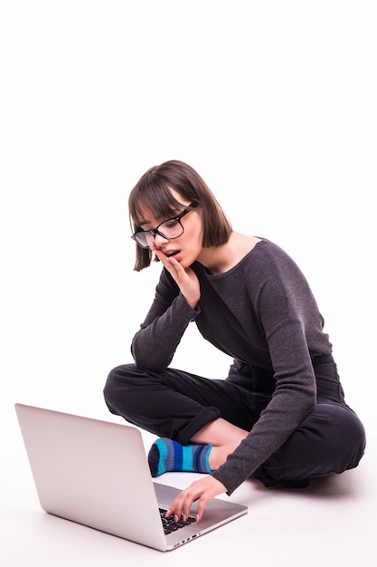 School, education, internet and technology concept - young teen girl sitting on the floor with laptop computer