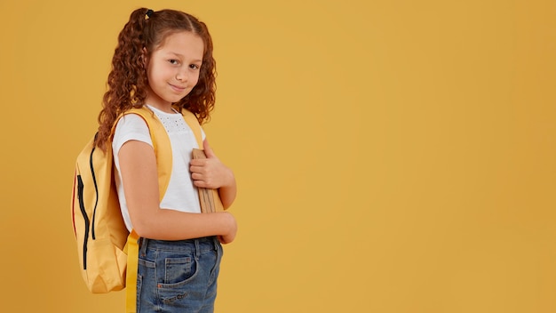 Foto gratuita scuola ragazza in piedi vista laterale lo spazio della copia