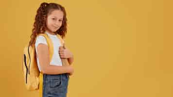 Free photo school girl standing side view copy space