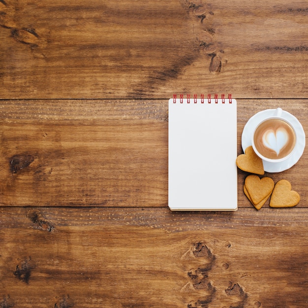 School notebook and coffee mug on a wooden background