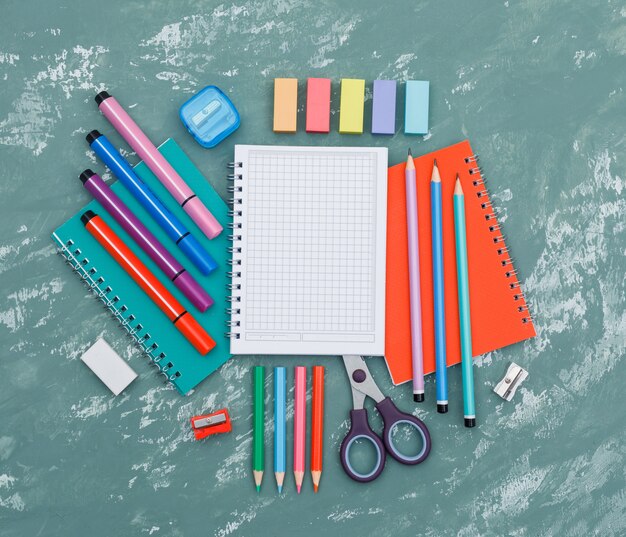 Free photo school reopening concept with notebooks, school supplies on plaster background top view.