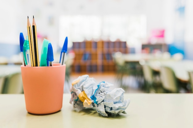 School stationery in cup on desk