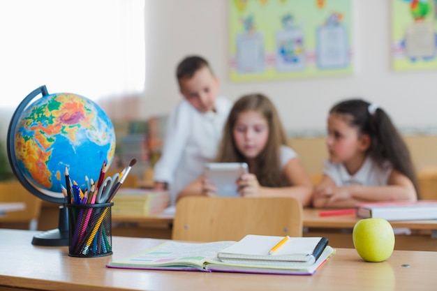 School supplies on desk and children