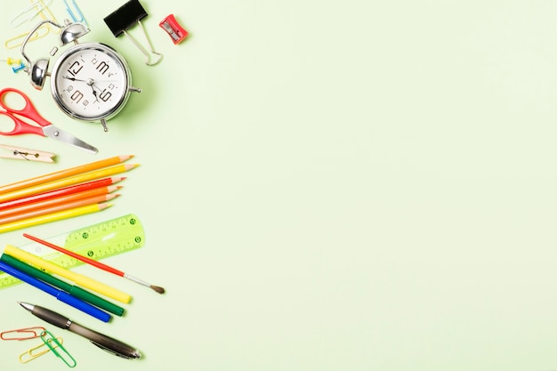 School supplies frame on light green background