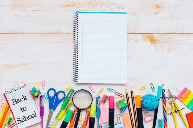 School supplies and notebook on wood background