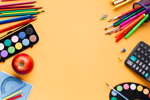 School supplies scattered on yellow table