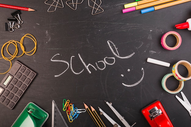 School supplies set on chalkboard