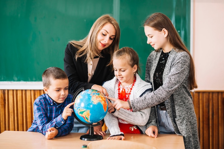 Бесплатный Фотография школьный преподаватель и студенты, работающие с земным шаром