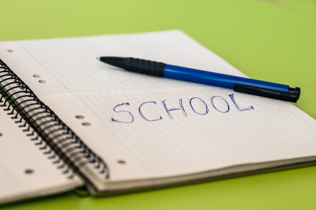 School text written on a notebook with pencils