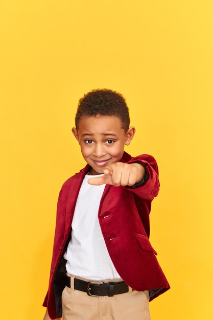 Schoolboy in bright velvet jacket pointing to the front