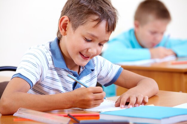 Schoolboy drawing with blue pencil