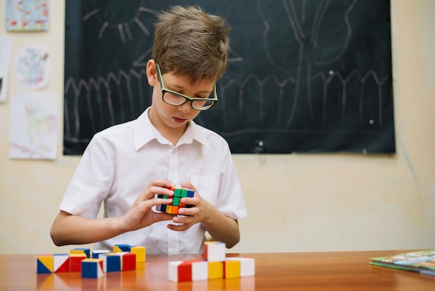 Free photo schoolboy solving puzzle in class