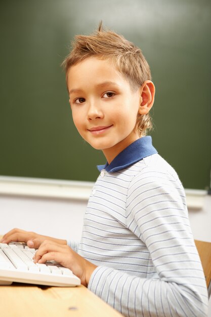 Schoolboy typing on the computer keyboard