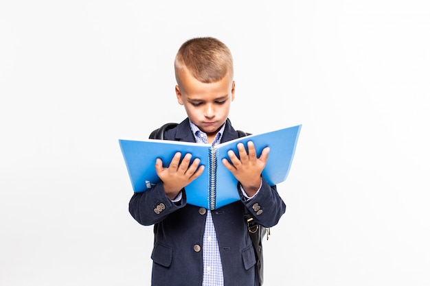 Free photo the schoolboy with the book in hands on a white wall